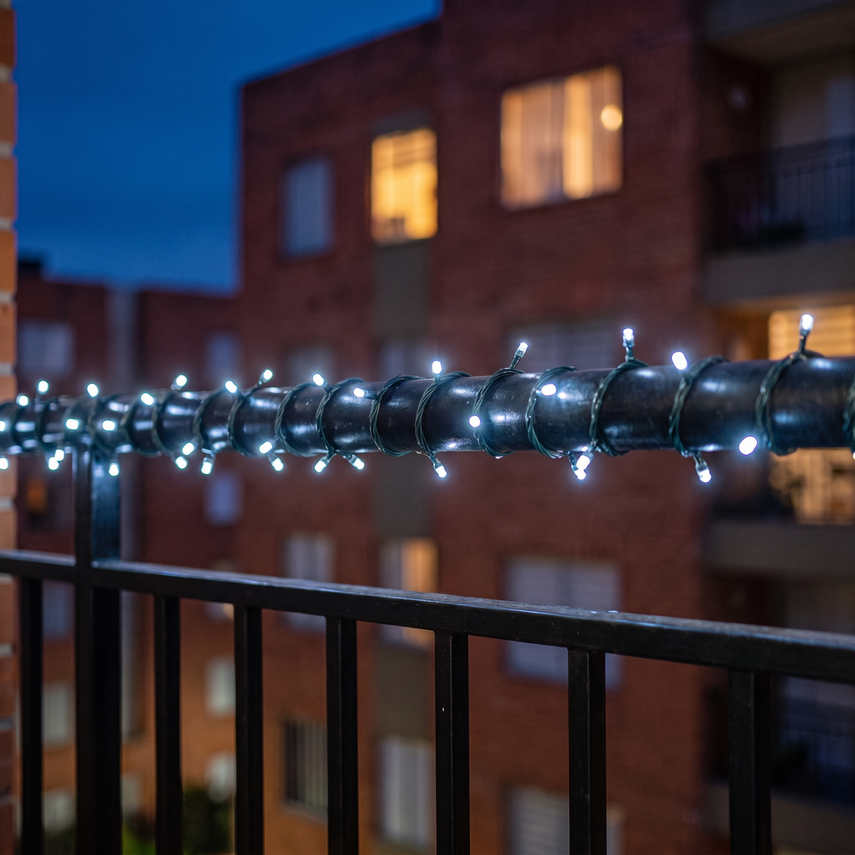 Luces solares ALUMBRA color blanca en la baranda de un balcón